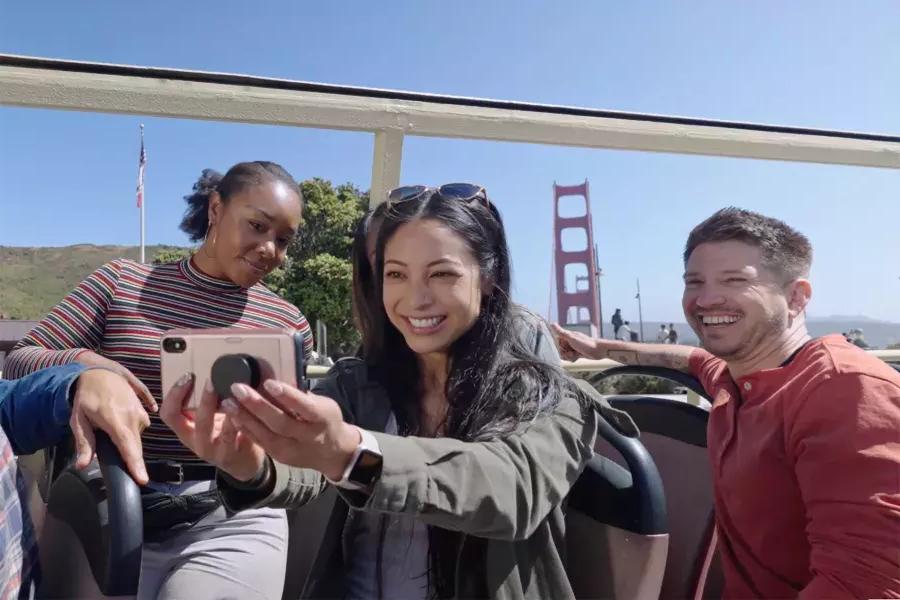 Un groupe de visiteurs prend un selfie lors d'une visite en bus près du Golden Gate Bridge. 贝博体彩app，加利福尼亚州.