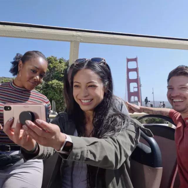 Un groupe de visiteurs prend un selfie lors d'une visite en bus près du Golden Gate Bridge. 贝博体彩app，加利福尼亚州.